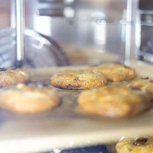 Versgebakken koekjes op een bakplaat in de oven, Makkermannetjes.